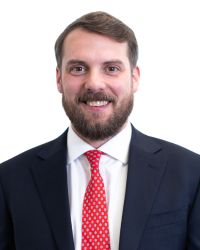 Terry Whittle headshot Terry Whittle black suit red tie white shirt